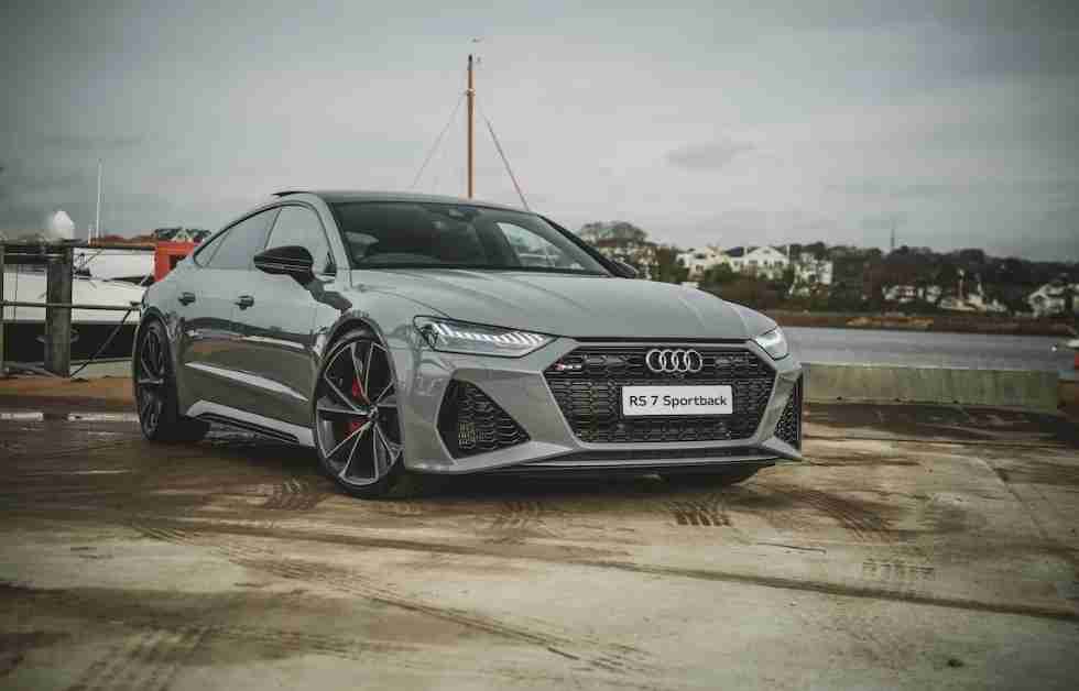 A yellow sports car is parked on a city street flanked by elegant buildings with large windows and arched entrances.